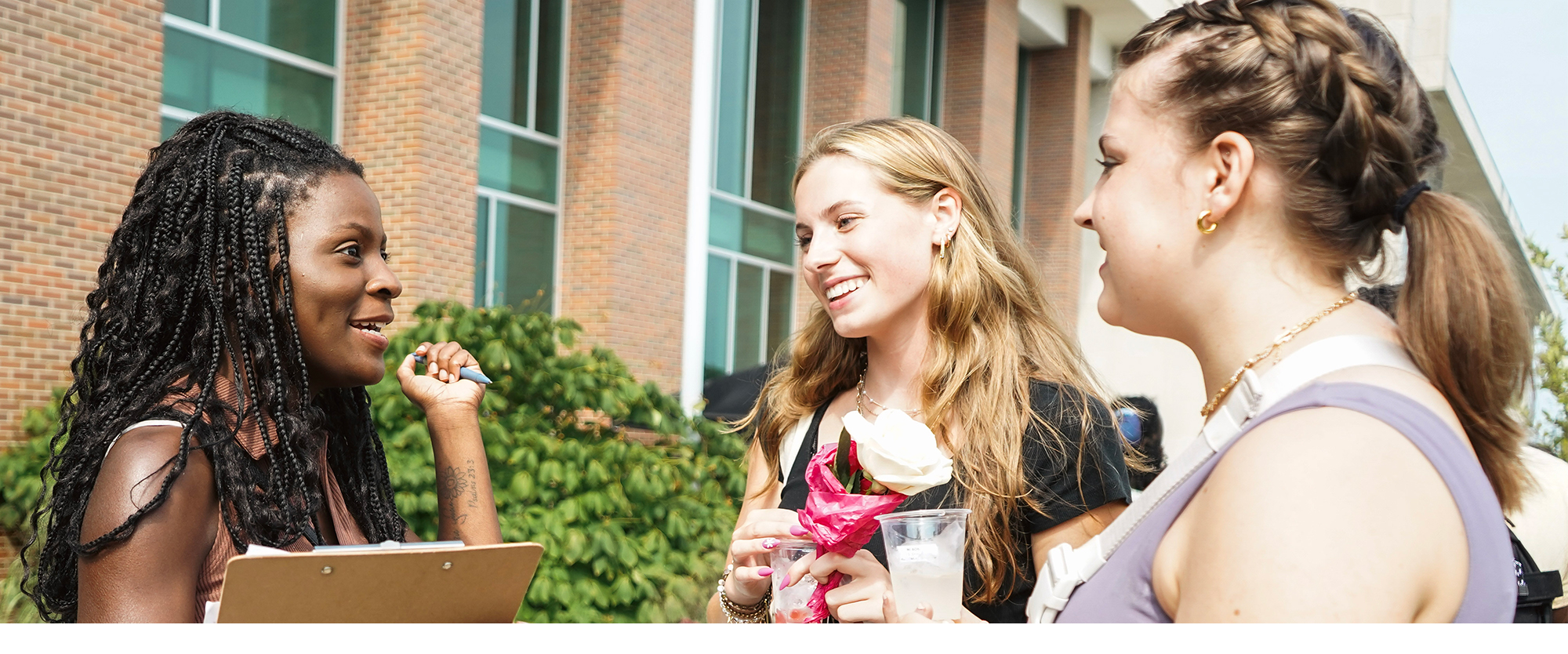Three young women standing and talking together.