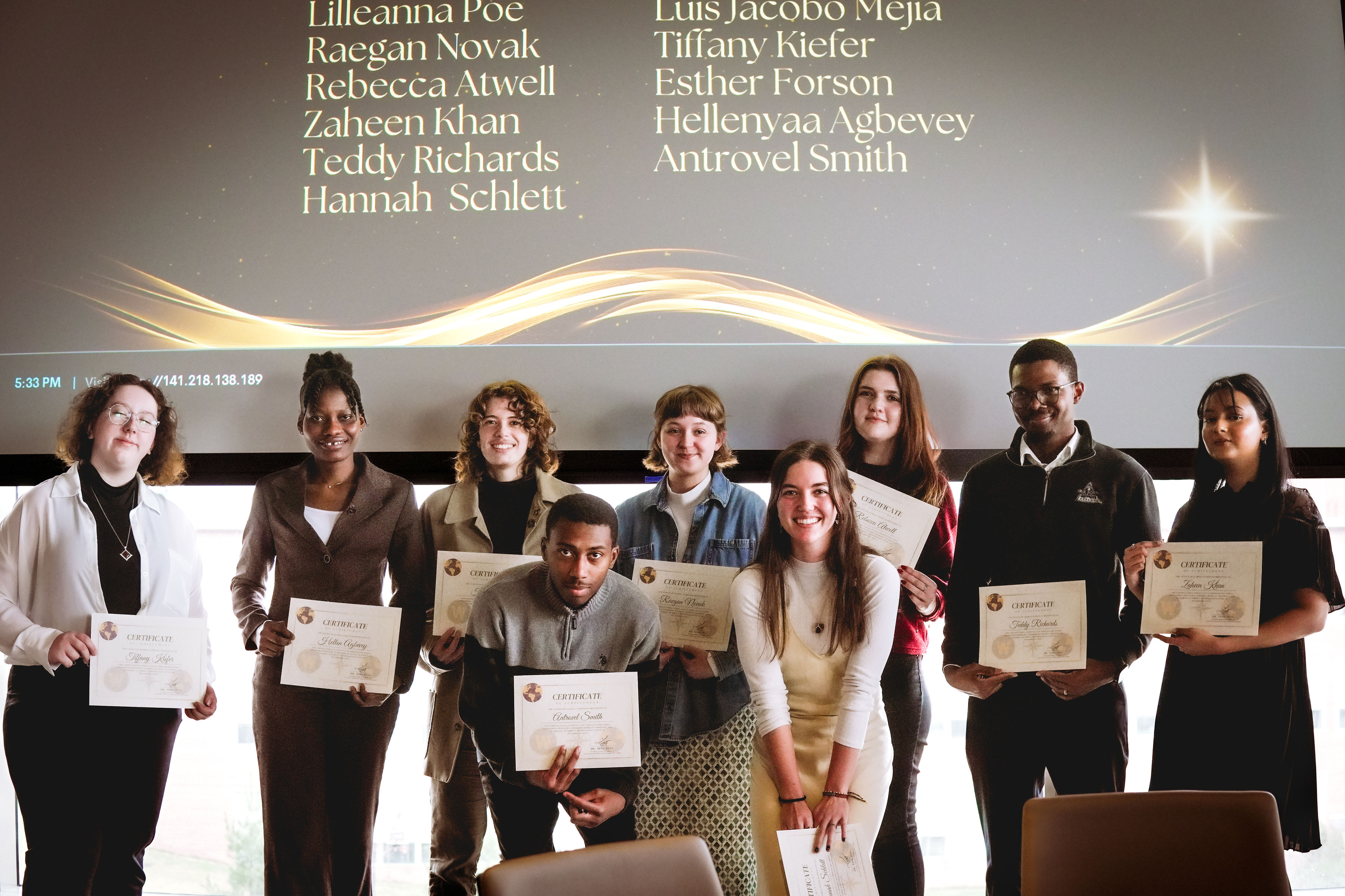 A group of students stand holding certificates at a Global Engagement Awards Program ceremony.