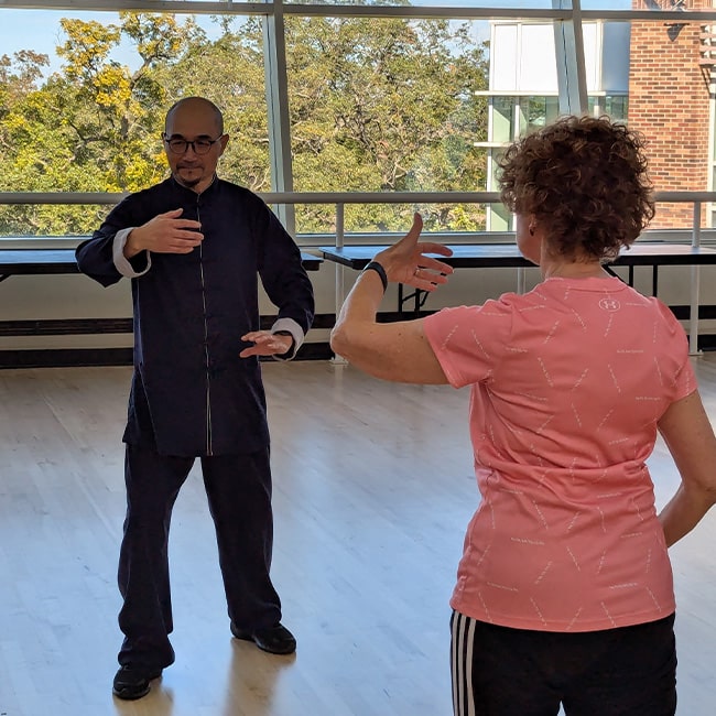 An OLLI member following a Tai Chi lesson from Chen Tao