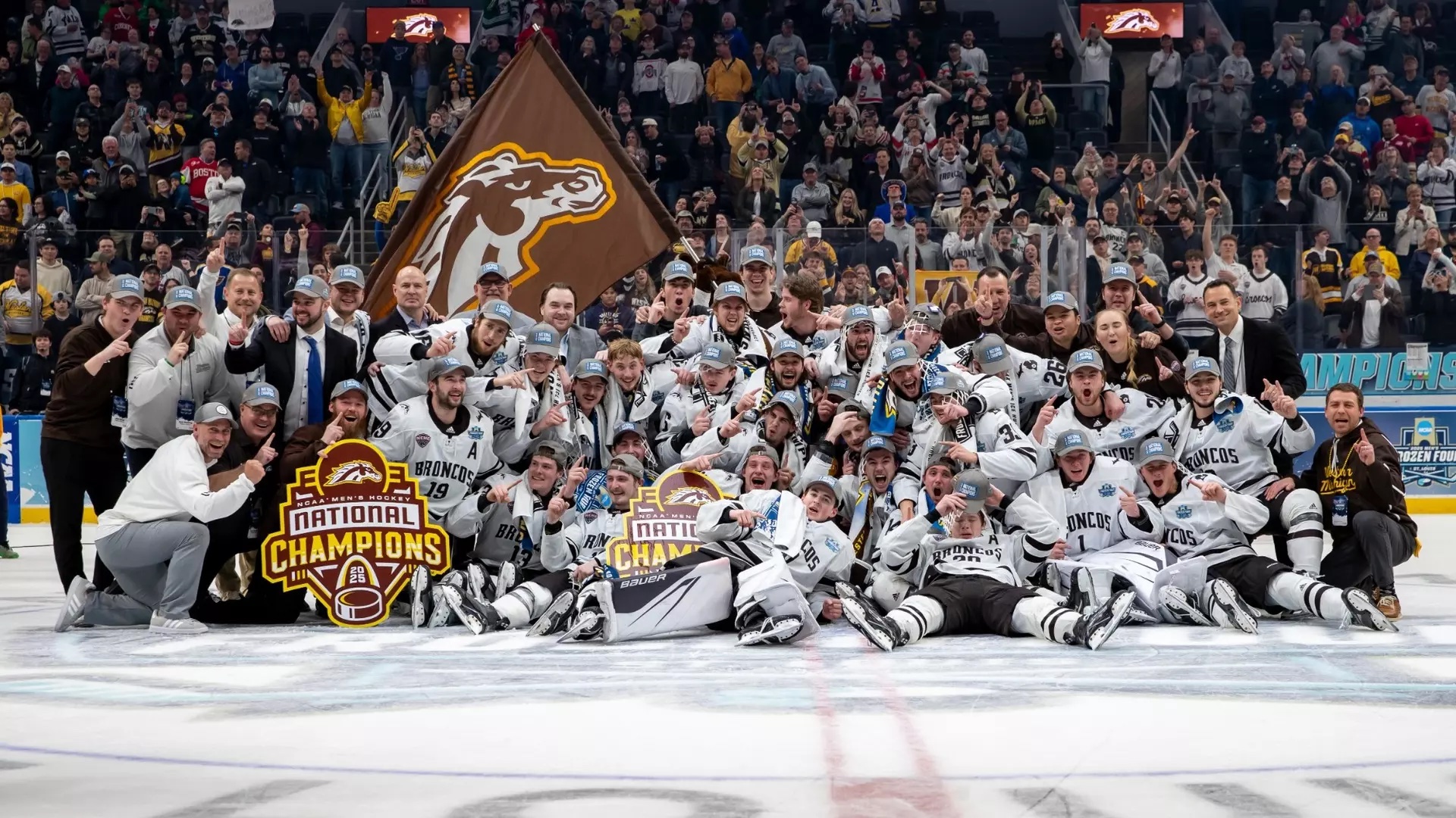 The WMU Hockey team holding up national champions signs on the ice.