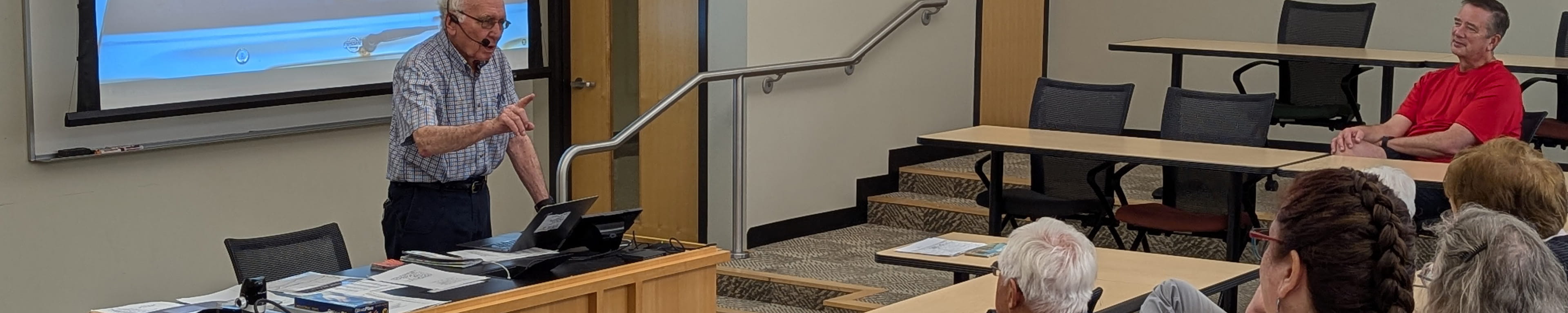 An image of an OLLI professor teaching a course on the history of road signs. 
