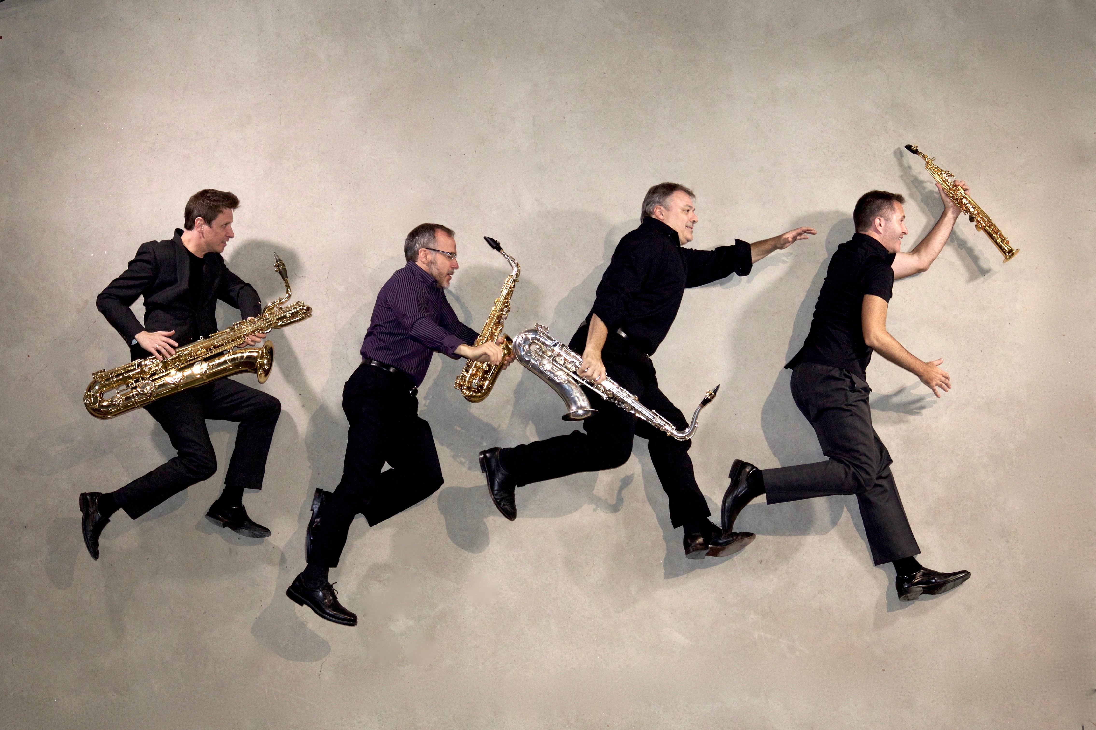 Four saxophonists jumping in the air
