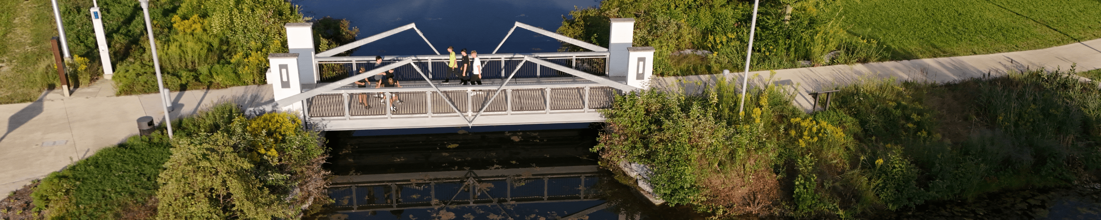 Students walking over the Goldworth Valley Pond bridge