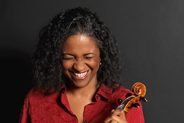 Smiling woman in a red shirt holding a viola.