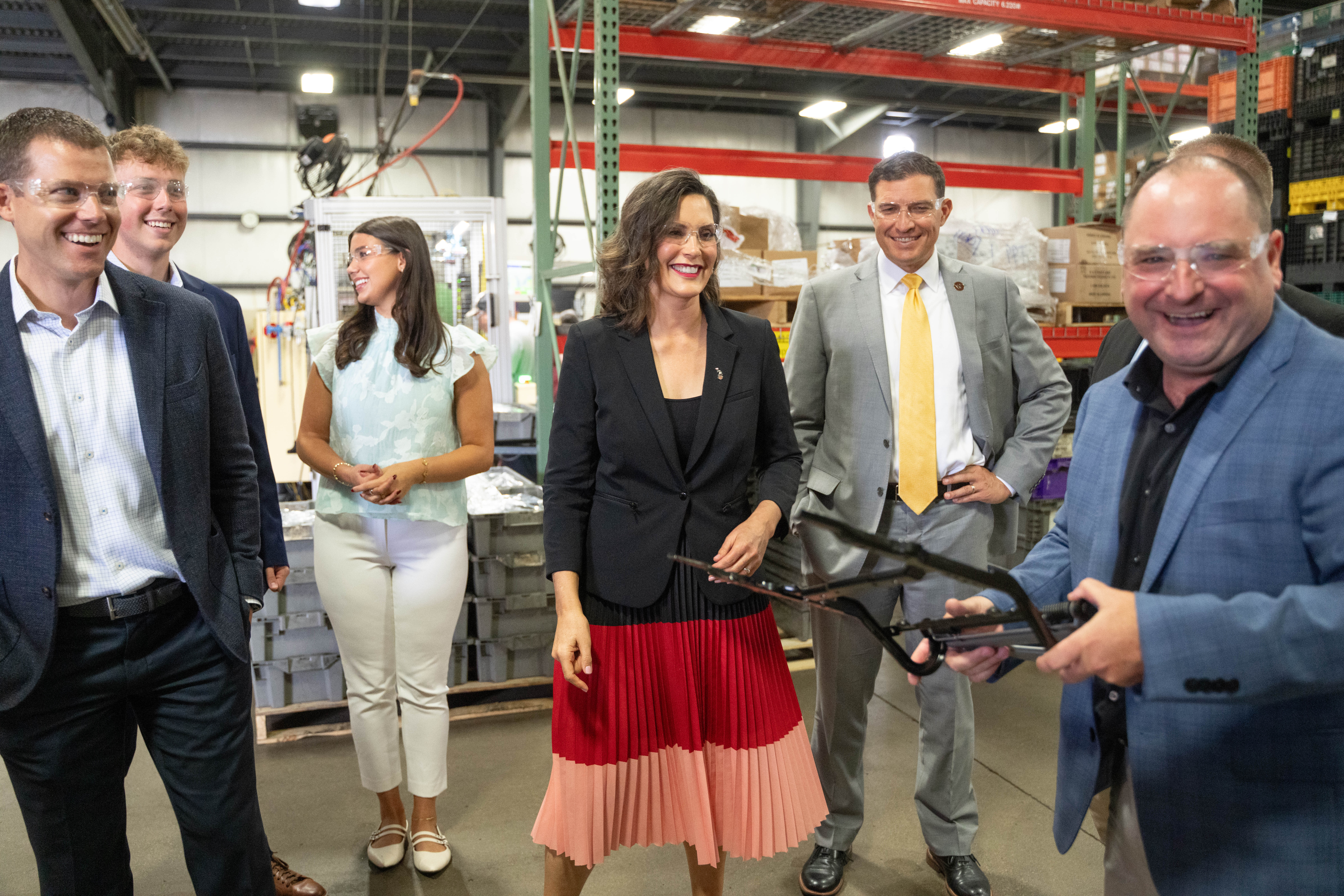 Governor Gretchen Whitmer talks with WMU President Russ Kavalhuna, Dr. Doug Lepisto and some students inside a manufacturing facility.