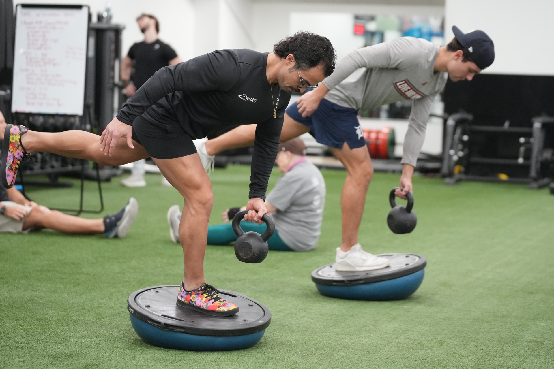 Dre lifting dumbbell with student