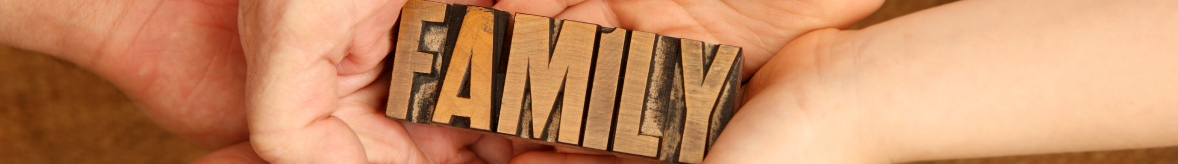 hands holding the word 'family'
