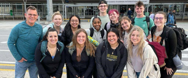 Group of students from WMU at an airport smiling
