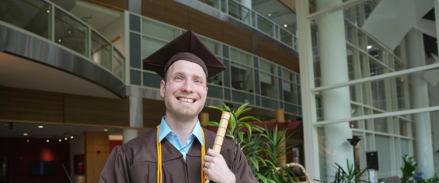 Male blind student posing in the college of health and human services by the stairs