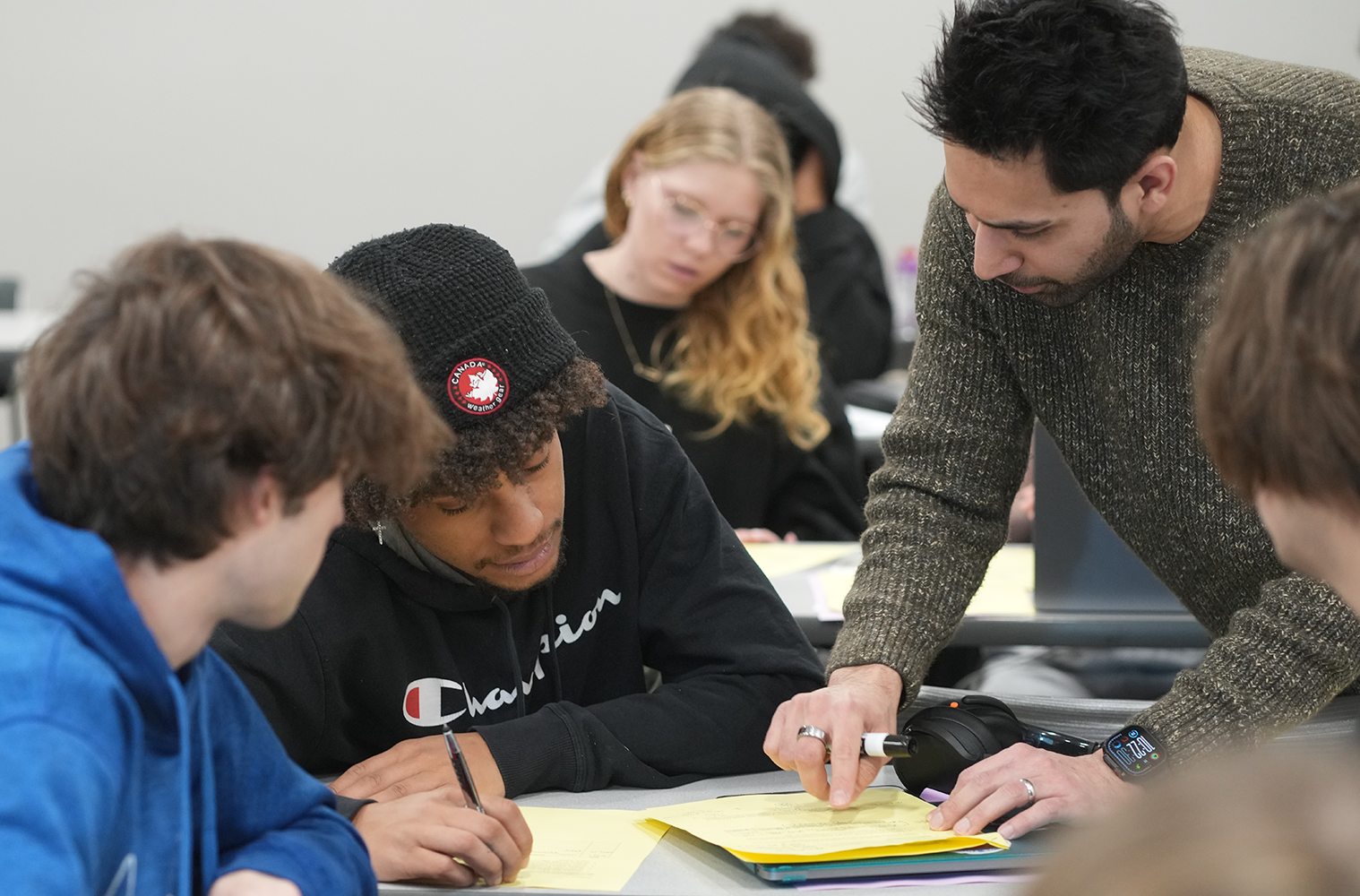 A Haworth College of Business instructor consults students in a classroom