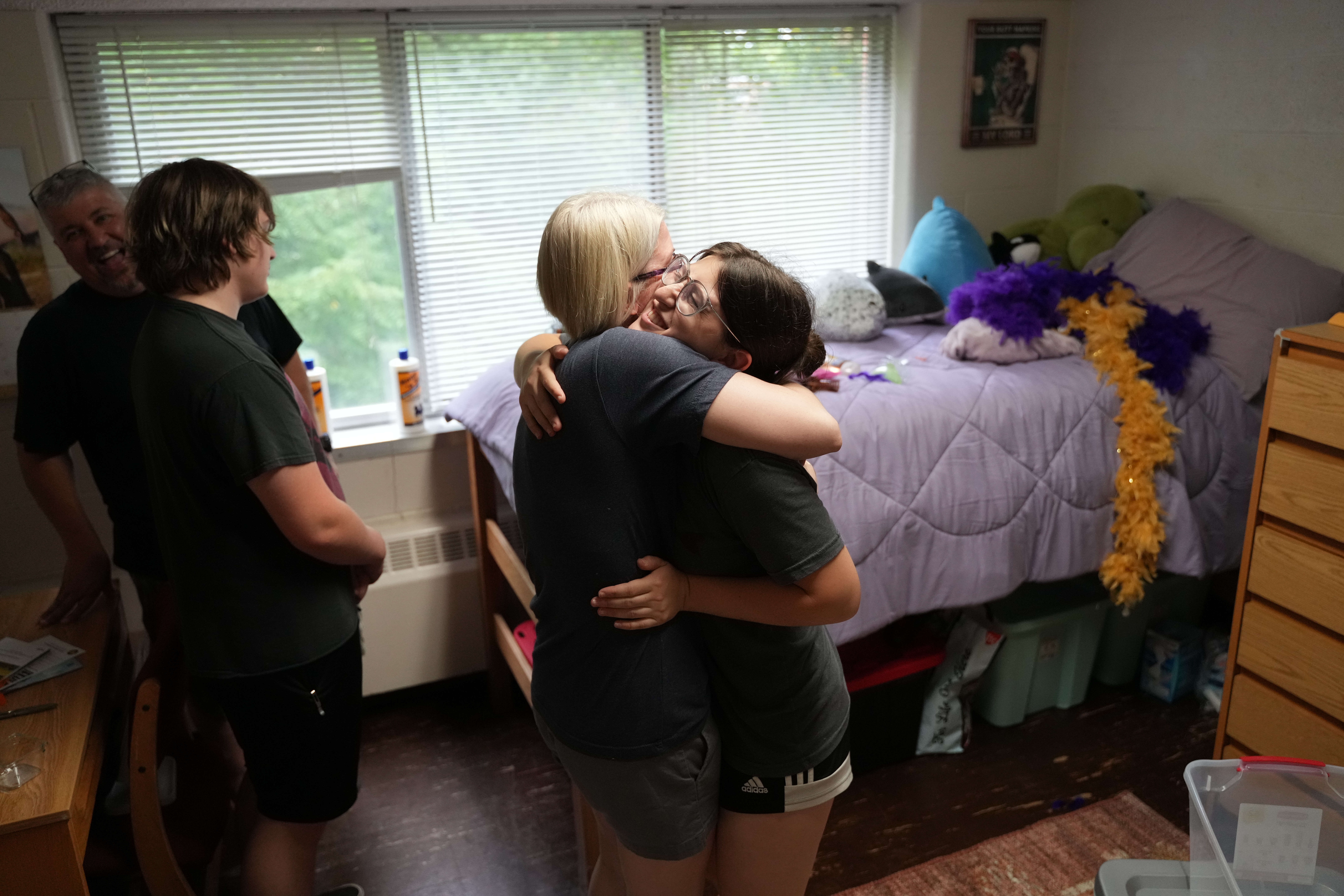 A parent hugs their student in their residence hall room on move in day.