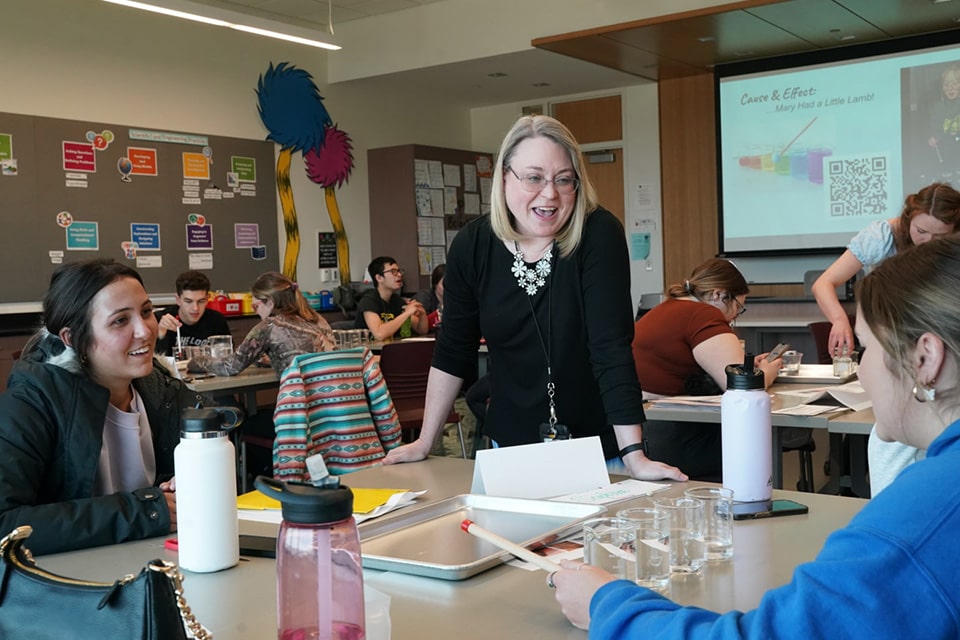 An instructor consults a group of students.