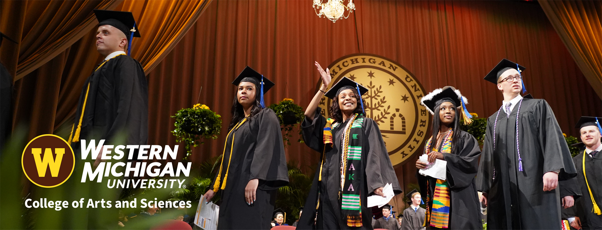 Students on stage in caps and gowns during graduation