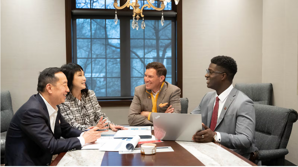 Zhang Financial Presidential Internship recipient sitting with President Kavalhuna and the Zhangs