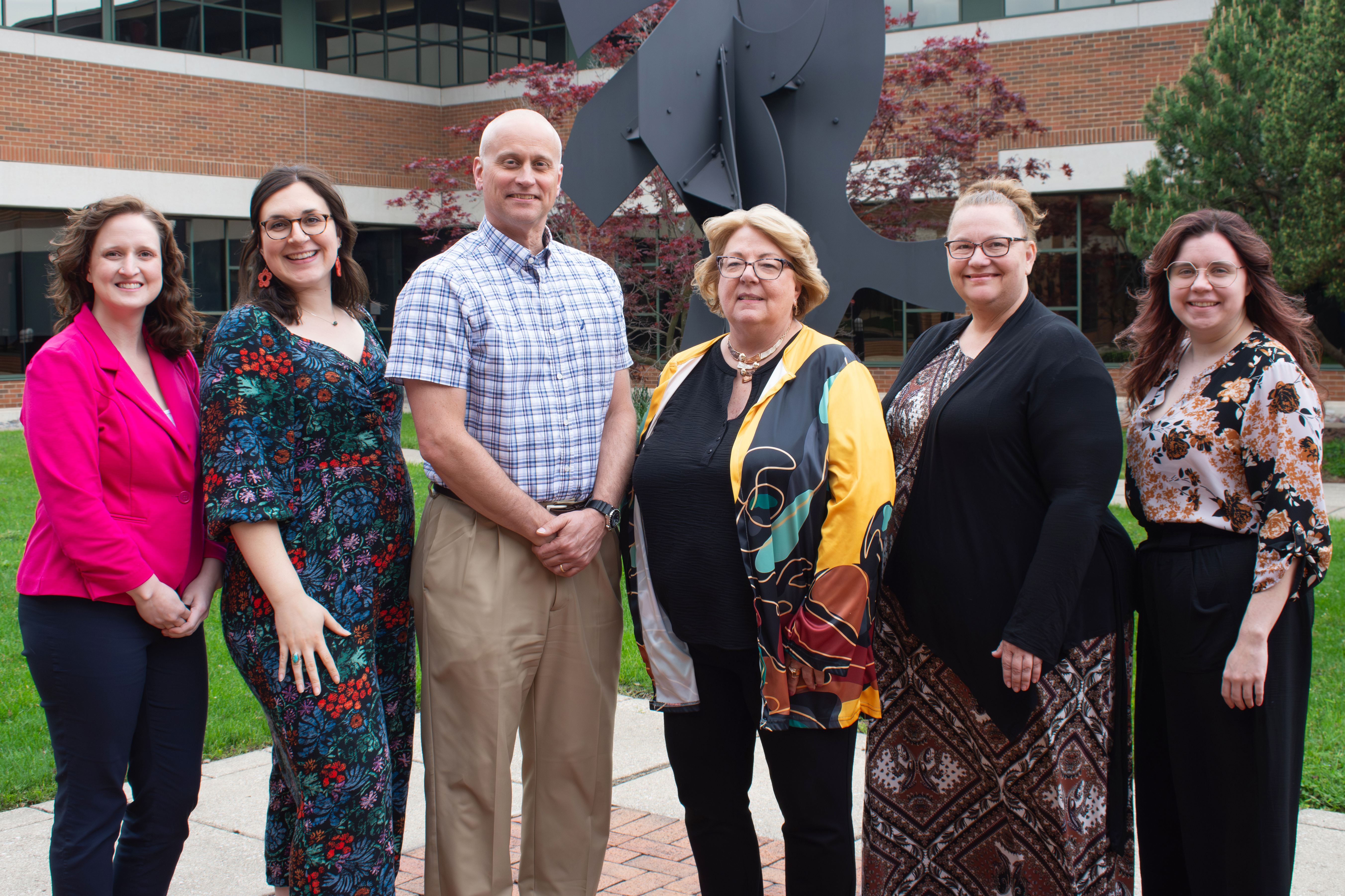 Geralyn Heystek stands with Zhang Career Center staff in the courtyard at Schneider Hall