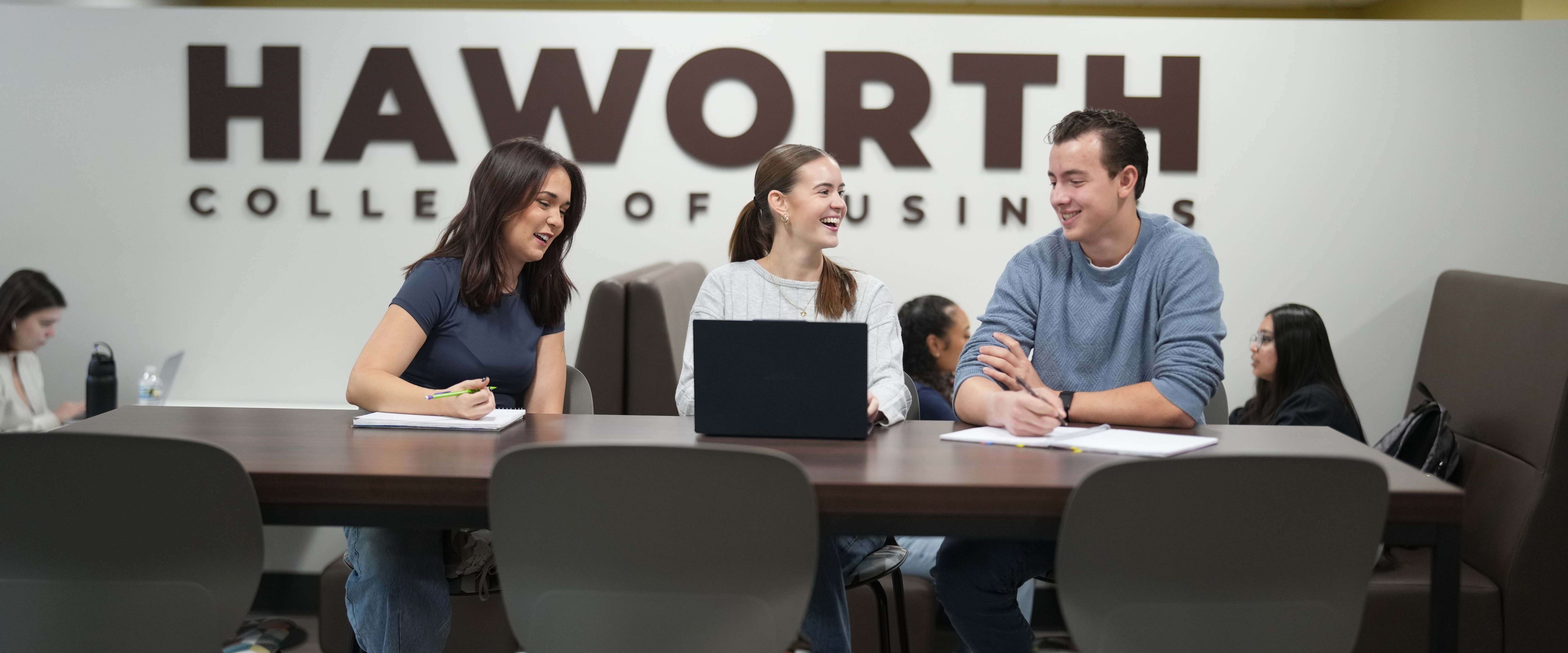 Three students working together at a table in the cafe
