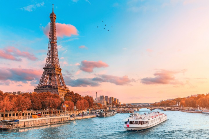 cruise ship floating on seine river next to Eiffel tower in Paris