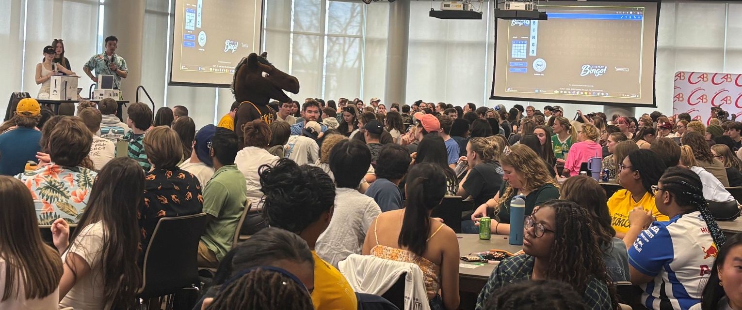 A large group of Western Michigan University students gathers and participates in a high energy Campus Activities Board Bingo event.