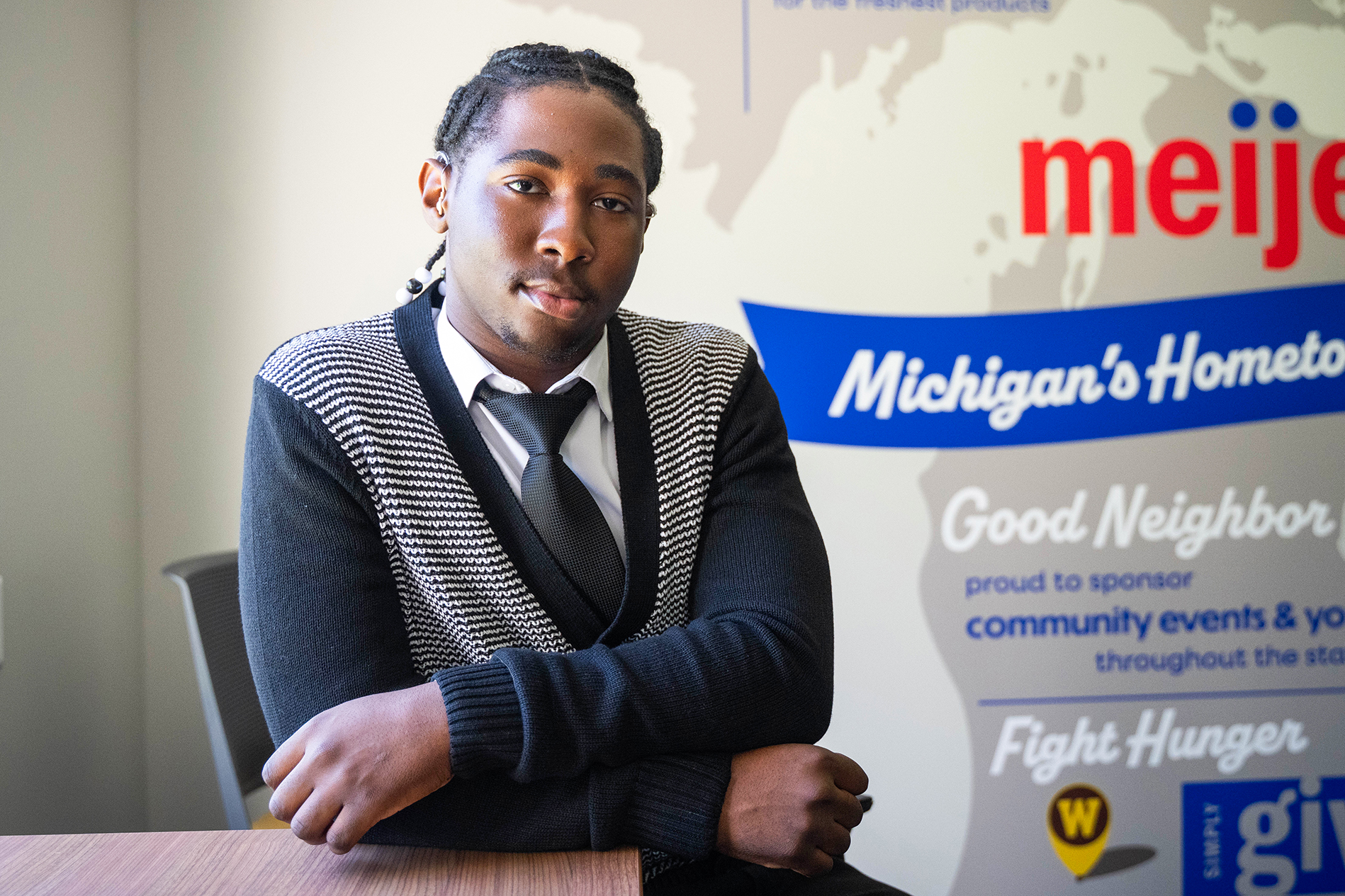 A man leaning on a table in front of the Meijer logo