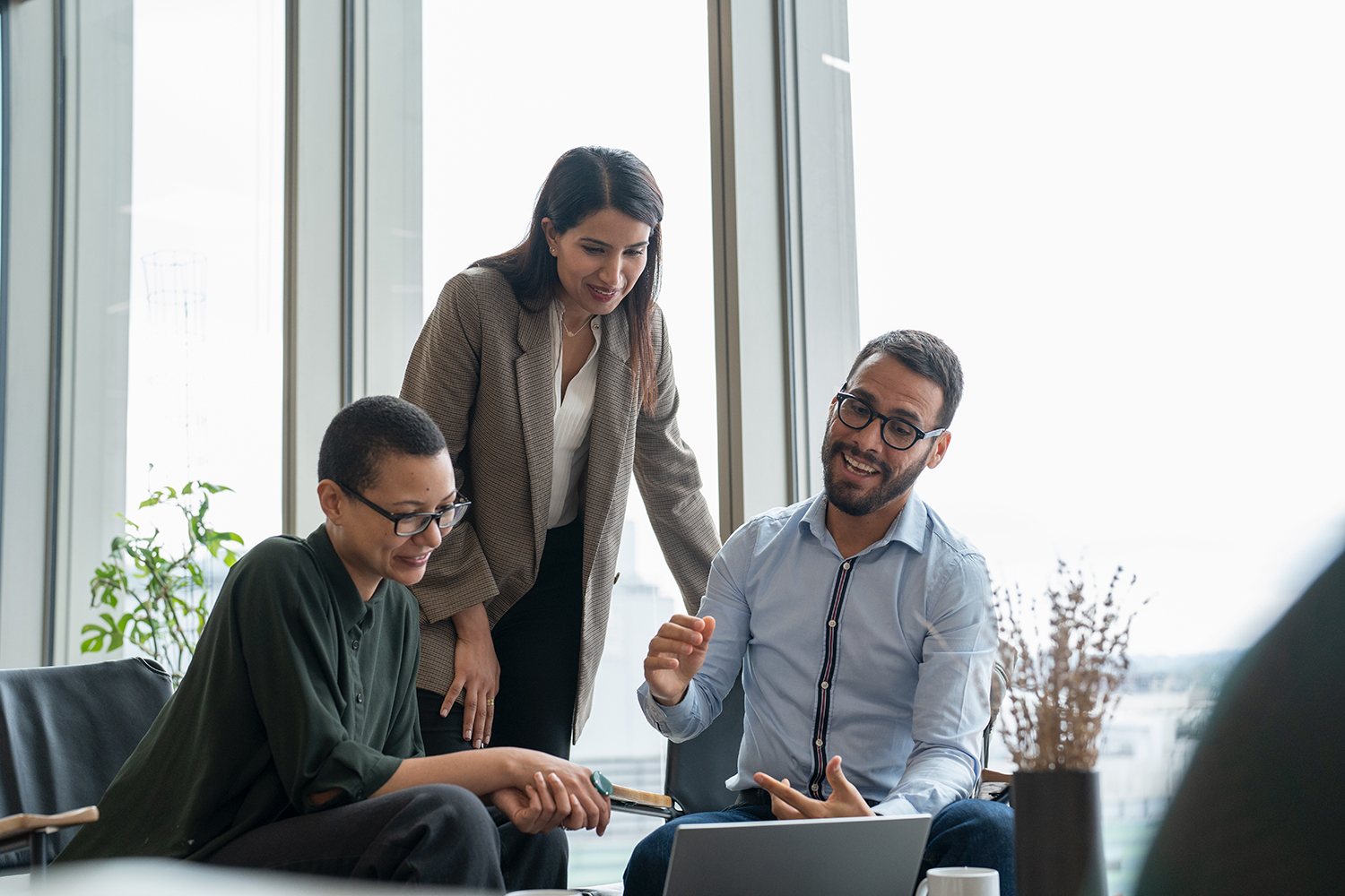 Small group of professionals looking at a laptop