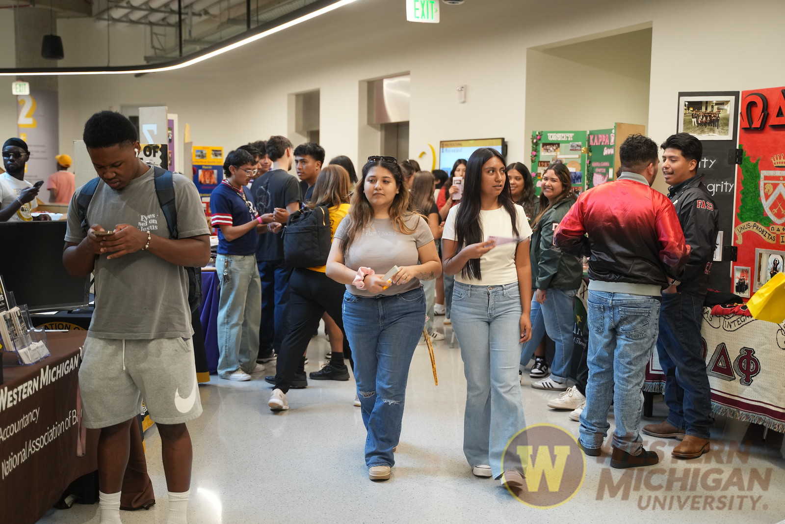 Racially diverse students talking to other students at the Student Center during an event.