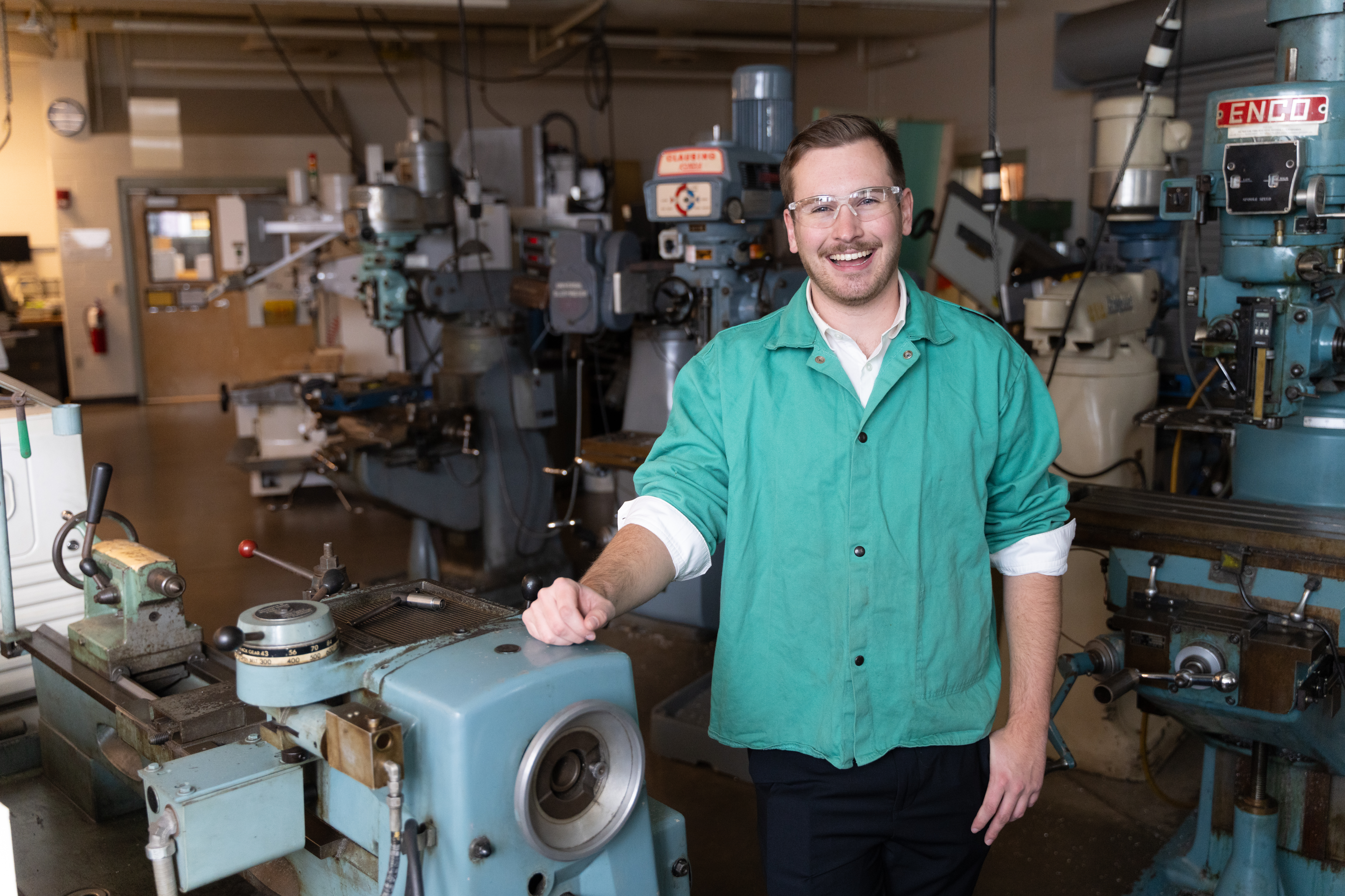 A graduate student with a manufacturing machine. 