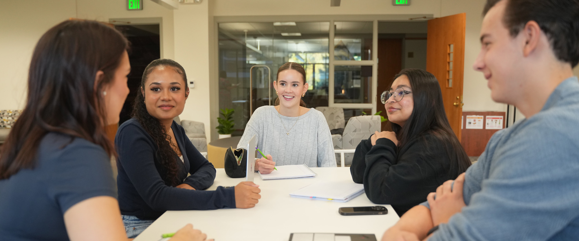 Students working at a table in the student lounge