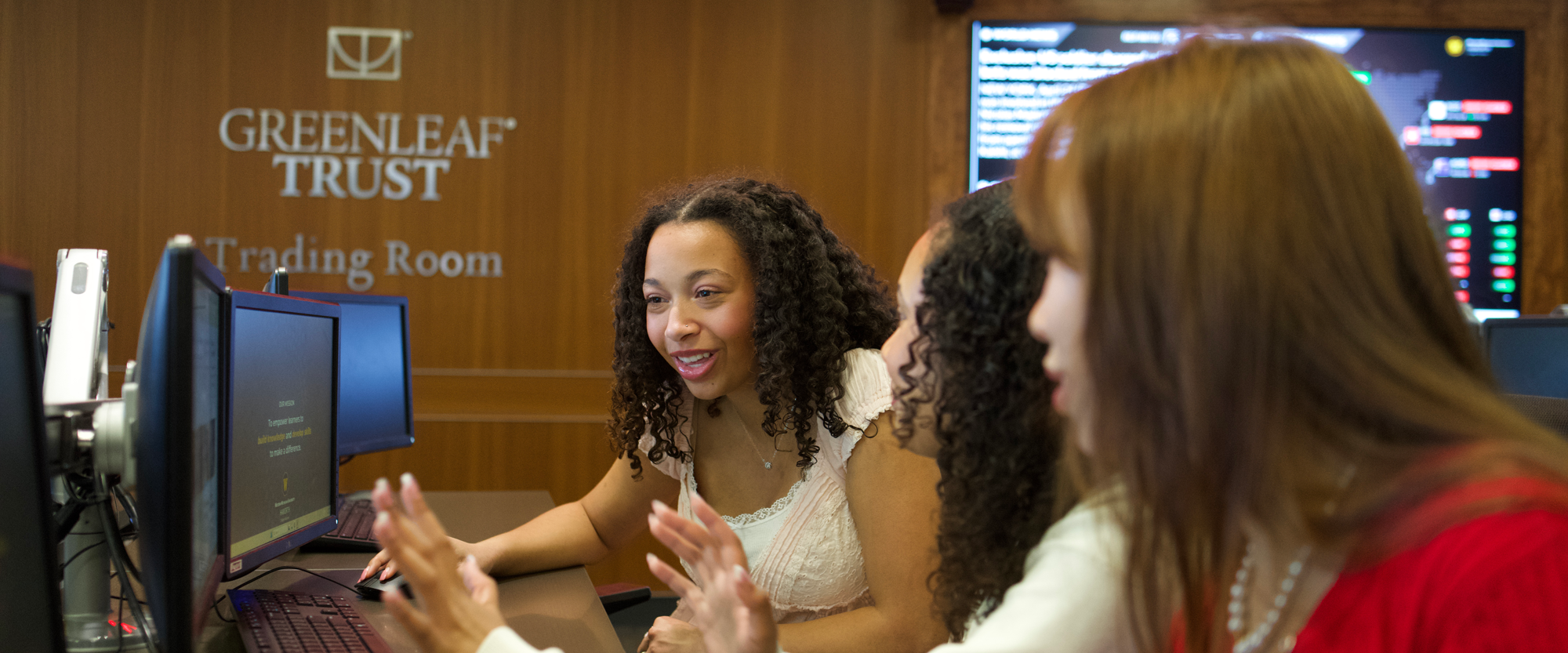 Three students working in the trading room