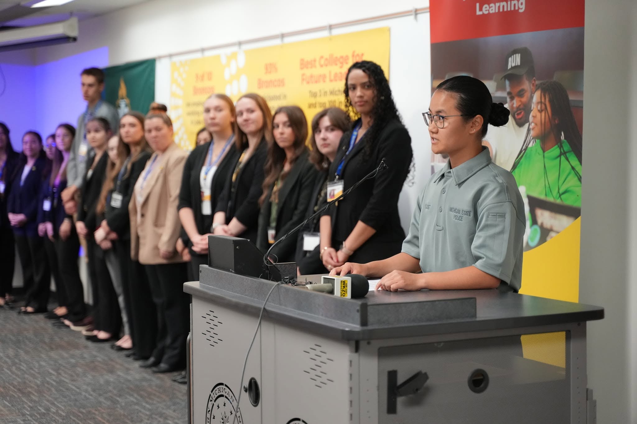 Maddy Mill speaking at a podium.