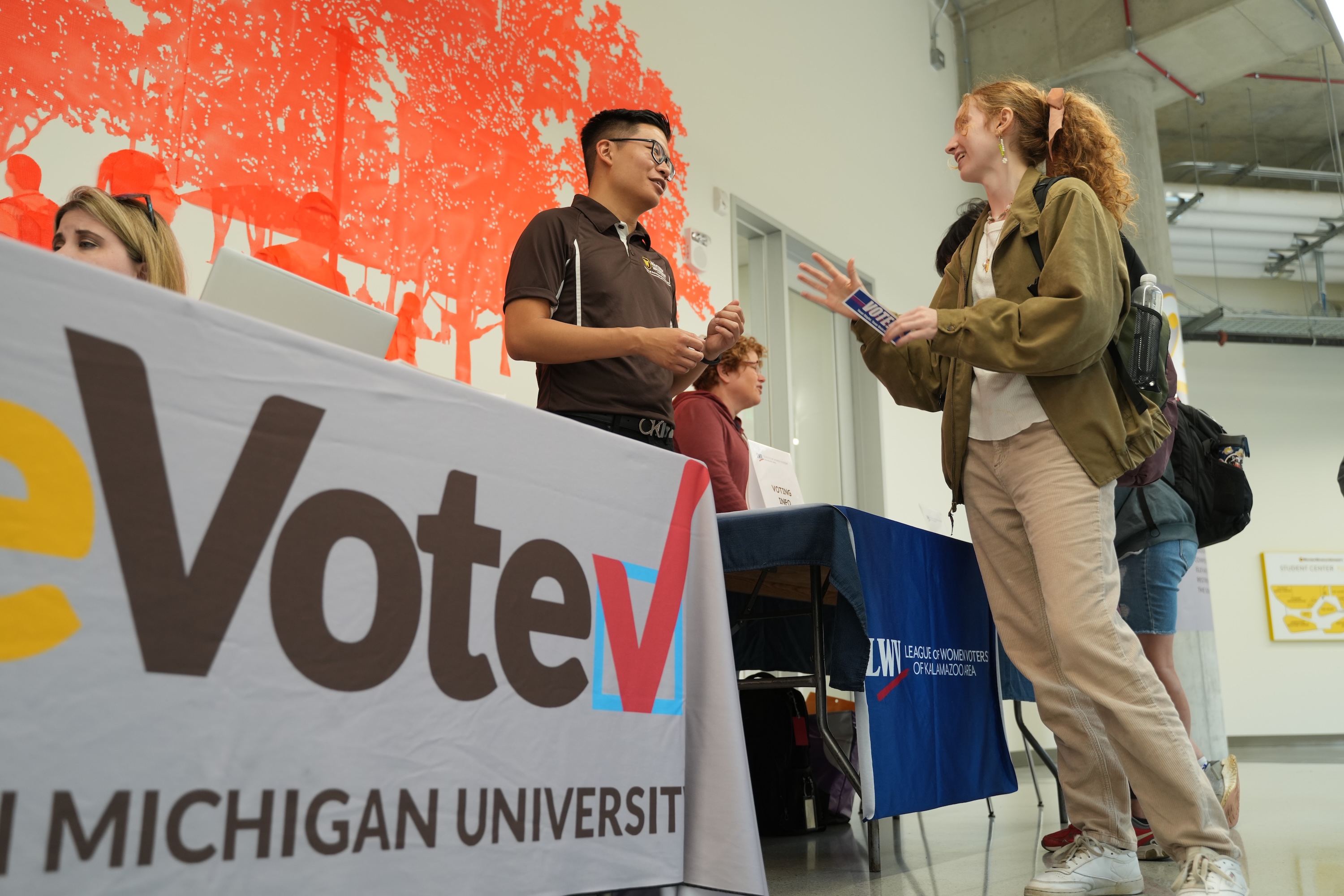 A student talking with a WeVote advocate in the WMU Student Center.