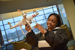 Student holding a robot.