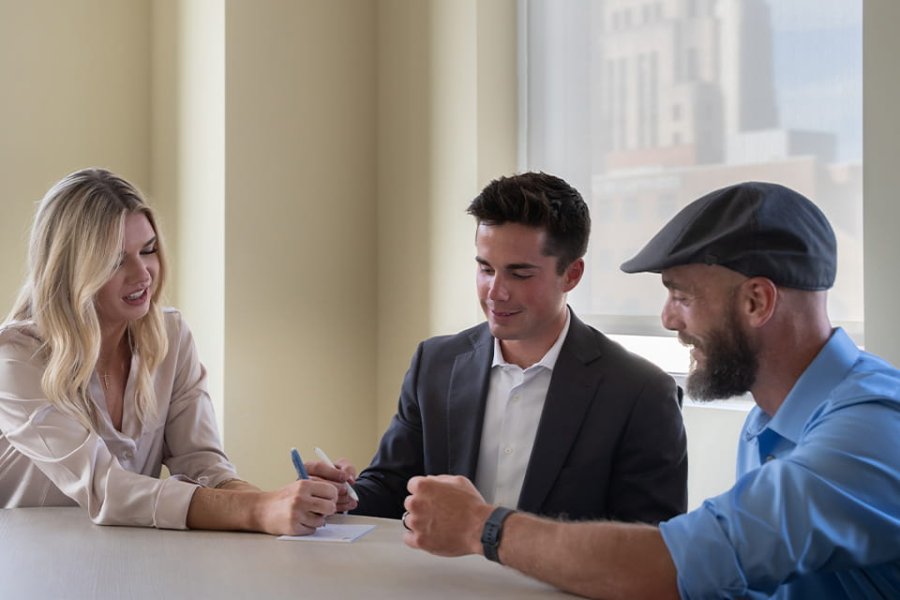Three business-oriented individuals discussing a topic at a round table. 