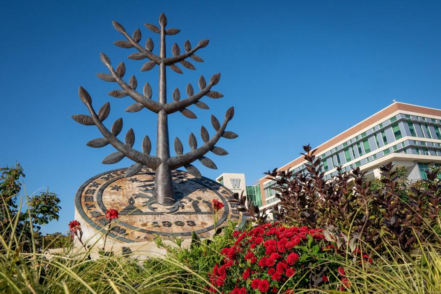 WMU seal statue amid foliage