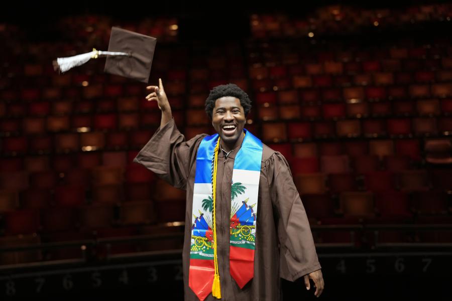 Donovan Boursiquot Wade tosses his graduation cap into the air.