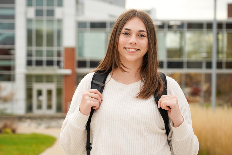 Katelyn Wandel wearing a cream sweater and standing on WMU campus