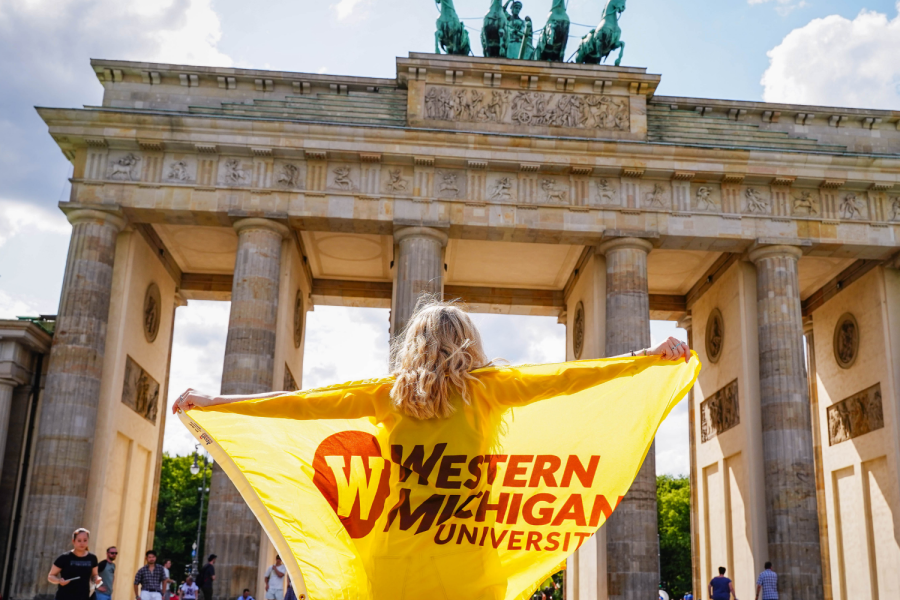 A student studying abroad and showing off the Western flag.