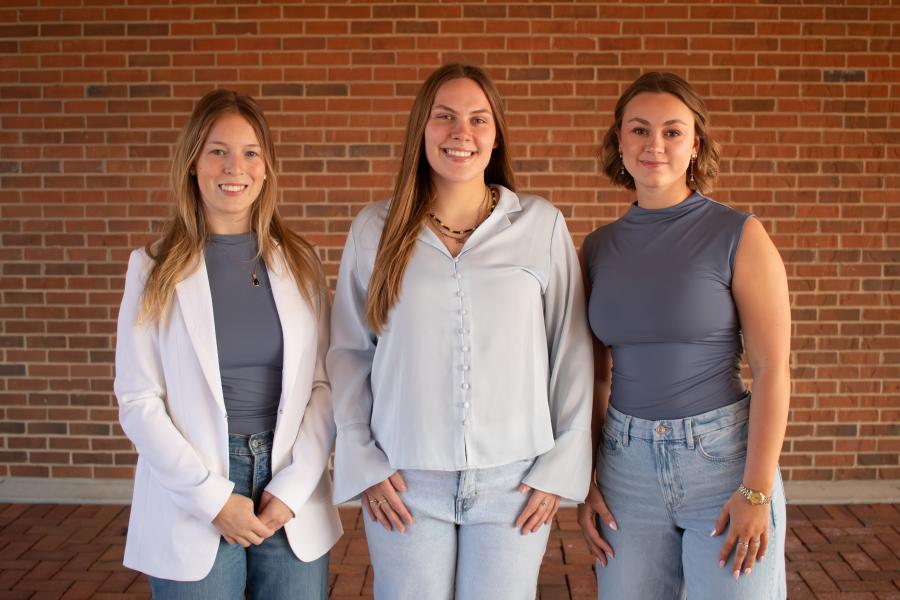 Three girls standing beside each other in a line 