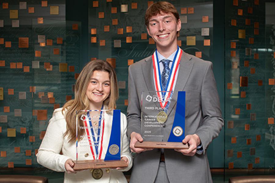 Two DECA students with their awards