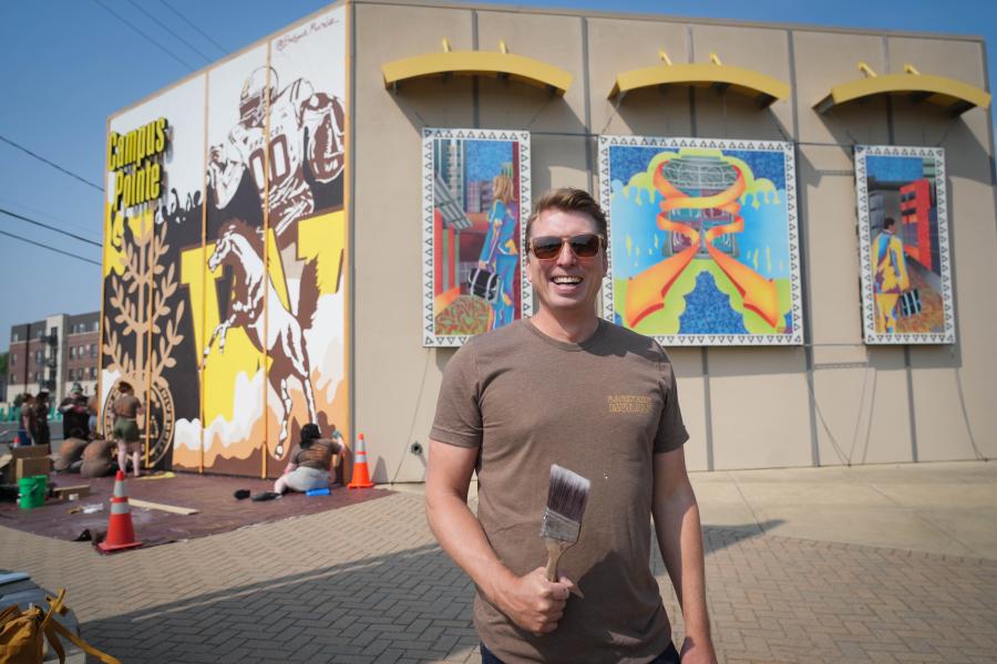 A portrait of Brad Zenz in front of his murals.