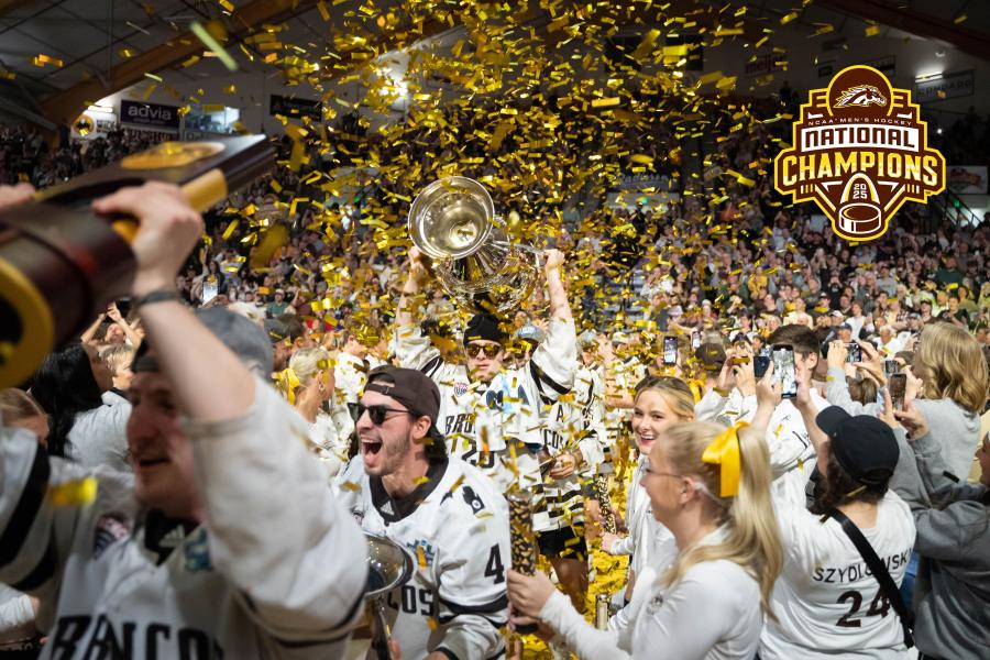 NCAA Men's Hockey National Champions 2025; The WMU hockey team holding up the trophy as gold confetti rains down on them in a packed Read Fieldhouse.