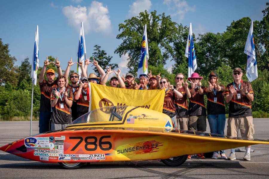 Members of the Sunseeker Solar Car Project stand with their vehicle.