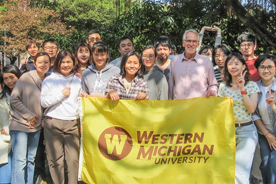 Taiwanese  participating in the Global Innovation MBA Program in Taiwan holding a Bronco flag.