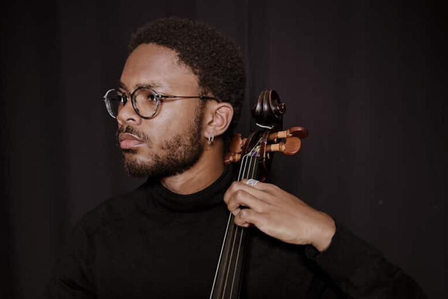 Portrait of Zachary Earle holding cello.