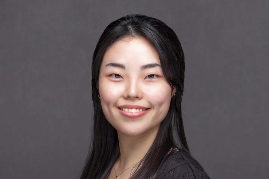 A smiling woman with long dark hair.