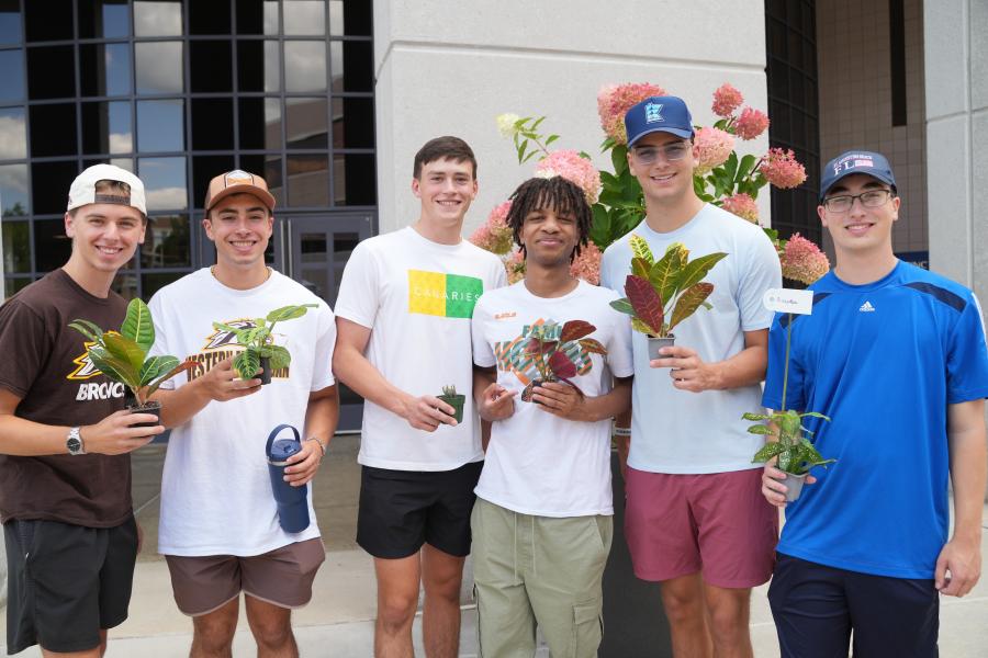 Students hold plants.