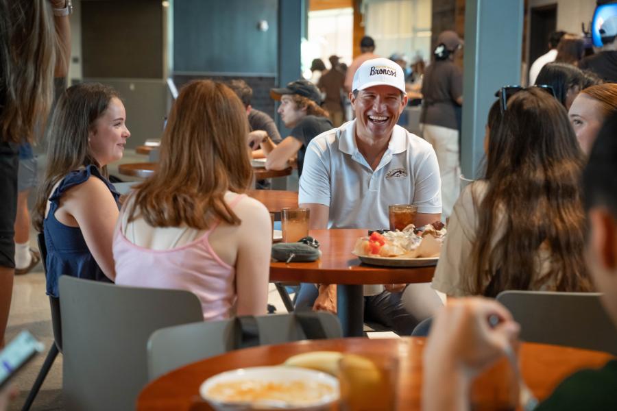 President Russ Kavalhuna sits with students at lunch.