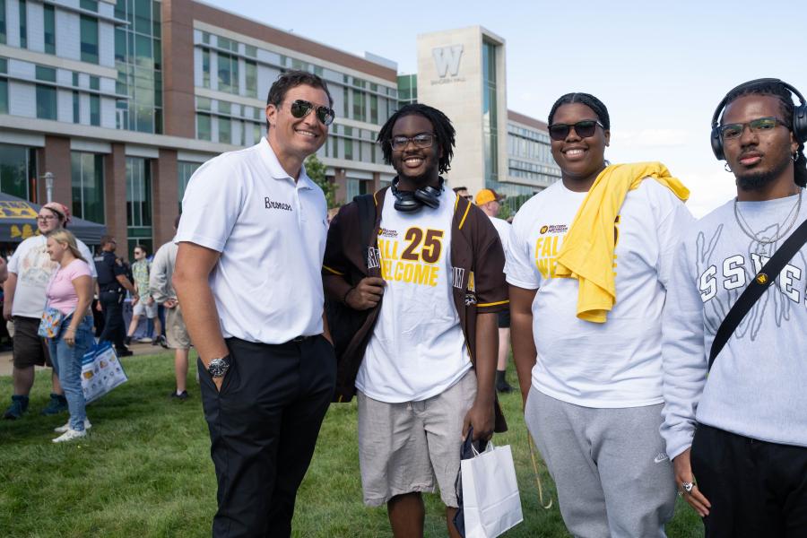 President Russ Kavalhuna stops for a photo with students at Bronco Bash.