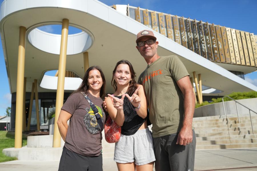 A family poses for a picture outside the student center.