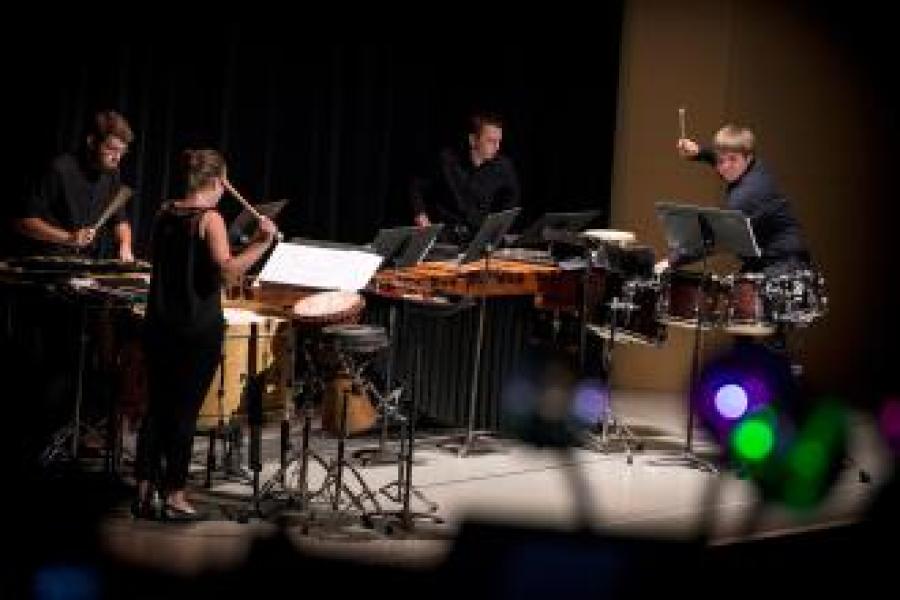A group of percussionists performs on stage.