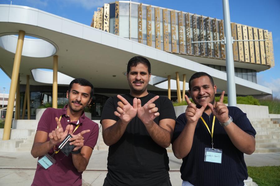 Students making W hands in front of the Student Center.